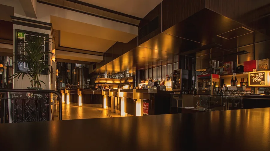 A long, low-lit bar counter glowing amber at night